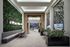 Modern lobby with lush vertical garden, stylish seating, and vibrant art pieces creating an inviting ambience.