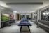 Chic recreational room with a modern pool table, sophisticated seating, and vibrant wall art creating an inviting ambiance.