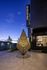 Elegant evening view of Hanover Burlingame with an intricate, illuminated sculpture casting captivating shadows on the walkway.