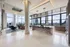 Luxurious open-concept apartment living room with panoramic city views, modern furnishings, and a sleek kitchen island.