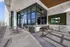Stunning rooftop terrace with modern seating, panoramic glass windows, and lush green accent wall, perfect for relaxation and entertainment.