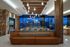 Luxurious modern apartment interior with elegant lighting, plush seating, stunning nighttime city views through expansive windows.