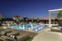 Luxurious rooftop pool with elegant lounge chairs and stunning sunset city skyline views.