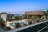 Luxurious rooftop pool and lounge area with contemporary design, outdoor seating, and lush greenery overlooking the city skyline.