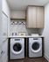 Chic laundry room with modern appliances, sleek wood cabinets, and stylish decor accents.