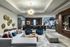 Elegant living room featuring a modern chandelier, stylish gray sectional sofa, and artistic decor with a vibrant abstract mural.