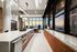 Luxurious open-concept kitchen and dining area with elegant marble countertops, modern appliances, and expansive city skyline views through floor-to-ceiling windows.
