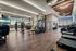 Luxurious apartment gym with state-of-the-art fitness equipment, panoramic city views, and stylish modern design.