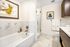 Elegant bathroom featuring luxurious marble tiles, a spacious tub, and a modern glass shower with stylish decor.