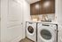 Modern laundry room featuring sleek Whirlpool washer and dryer, elegant cabinetry, and stylish decor.