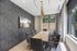 Modern and inviting conference room featuring stylish gray chairs, a sleek wooden table, and large windows offering natural light and a view of lush greenery.