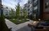Chic apartment courtyard featuring lush greenery, cozy outdoor seating, modern fire pit, and ambient string lights.