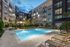 Luxurious apartment complex showcasing a stunning outdoor pool area with modern lounge chairs and lush greenery, perfect for relaxation and leisure.