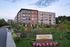 Charming apartment complex at dusk with lush green landscaping, modern architecture, and vibrant flower beds, showcasing tranquil living at Hanover Stoneham.