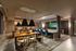 Luxurious interior featuring a sleek dining area with wooden tables, stylish blue chairs, and modern pendant lighting, perfect for entertaining in style.