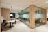 Modern, elegant workspace with glass walls, cozy seating area, and stylish lighting.