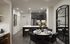 Elegantly designed modern kitchen and dining area with sleek dark cabinets, stainless steel appliances, and a chic round dining table set for four.