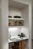 Elegant built-in desk nook with stylish shelving, decorative vases, and books, ideal for a modern home office.