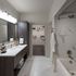 Luxurious bathroom with elegant vanity and spacious walk-in closet, featuring modern fixtures and stunning tiled shower.