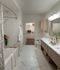 Luxurious bathroom with elegant marble tiles, modern fixtures, and a spacious walk-in closet.