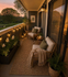 Charming balcony with cozy seating, ambient string lights, and lush greenery, perfect for serene sunset views.