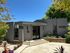 Inviting entrance of Foothill Heights Apartments surrounded by lush greenery and modern architecture under a clear blue sky.