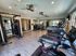 Modern fitness center with state-of-the-art equipment, including treadmills, exercise bikes, and weight machines in a bright and spacious setting.