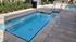 Inviting outdoor pool area featuring a cozy hot tub and vibrant landscaping, perfect for relaxation and leisure.