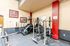Well-equipped fitness room featuring exercise machines and weights with vibrant decor.