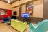 Modern entertainment room with colorful seating, sports-themed decor, and a large TV.