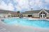 Inviting swimming pool in a modern apartment complex with elegant architecture and sunny skies.