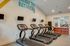 Contemporary fitness room with four treadmills and motivational decor.