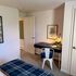 Bright corner workspace in cozy bedroom with sleek desk and modern chair.