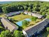 Aerial view of a picturesque apartment complex with lush greenery and a central sports court.