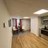 Charming dining area with round table, two chairs, and modern kitchen appliances adjacent.