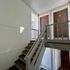Bright stairway with two doors leading to separate units, featuring sleek design and natural lighting.