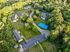 Aerial view of a lush apartment complex with modern buildings, a basketball court, and abundant greenery.