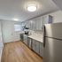 Contemporary kitchen with stainless steel appliances, minimalist light fixtures, and elegant cabinetry.