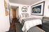 Modern bedroom with stylish decor, a cozy bed, and elegant wall art.