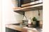 Compact kitchen area with sleek stainless steel appliances, a small sink, and a touch of greenery for a modern vibe.
