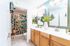 Bright bathroom with colorful mosaic shower curtain, dual sinks, and modern decor.