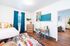 Bright and stylish bedroom with colorful decor, a cozy workspace, and artistic elements.