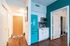 Welcoming entryway with vibrant teal kitchen accents, highlighting modern urban living.