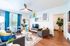 Contemporary living room featuring modern furnishings, vibrant artwork, and abundant natural light.