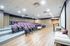 Bright and modern theater room with tiered seating, projector screen, and comfortable furnishings.