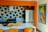 Modern kitchen with hexagonal tile backsplash, stainless steel appliances, and vibrant artwork adding a splash of color.