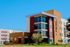 Contemporary apartment complex with large windows, vibrant exterior design, and lush landscaping at River Trail Village.