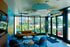 Bright and welcoming lobby with trendy seating, large windows, and vibrant mural overlooking lush outdoor spaces.