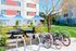 Vibrant apartment courtyard featuring modern outdoor seating, colorful umbrellas, bike racks, and lush green lawns for relaxation and leisure.