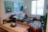 Inviting living room with modern decor featuring a cozy gray sofa, vibrant artwork, and natural light streaming through large windows.